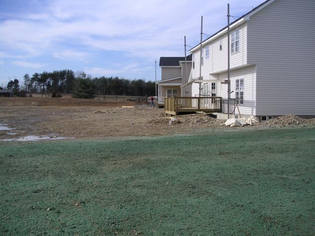 View from middle of back yard, next door neighbor's deck and yard