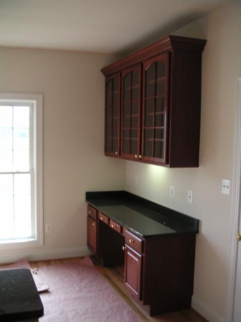 Built in desk and cabinets in morning room, door to the right is garage door