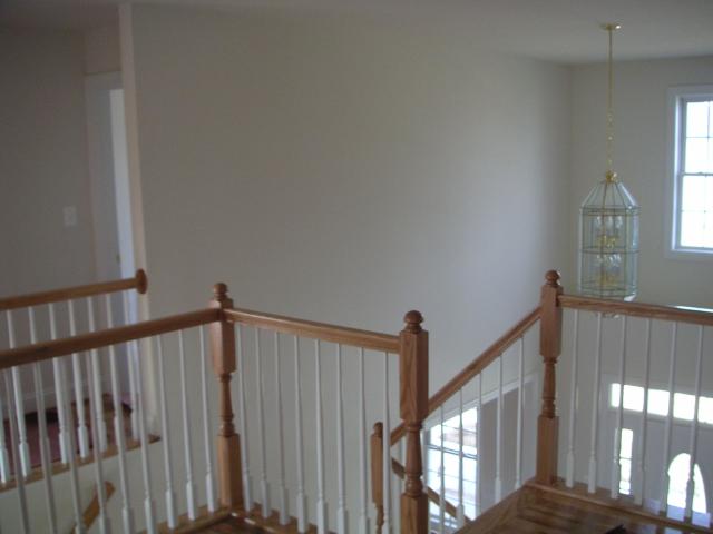 Looking from back left corner of landing to the foyer on the right and guest bedroom to the left