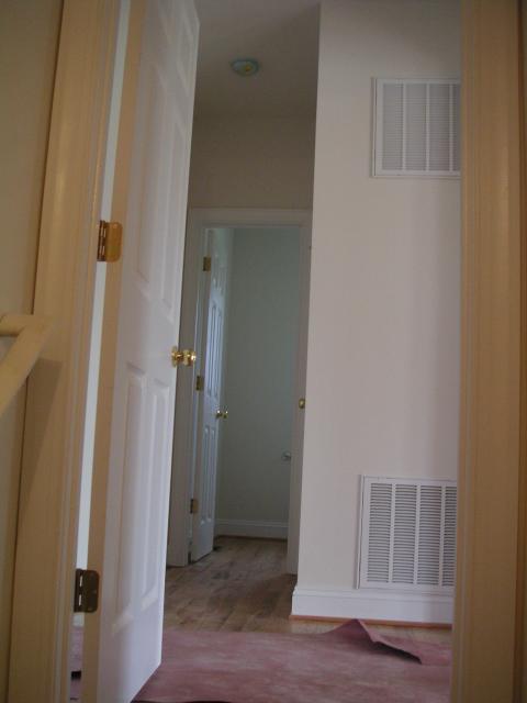 Looking from top of basement stairs through to the 1/2 bath, there is a coat closet on the right before the 1/2 bath